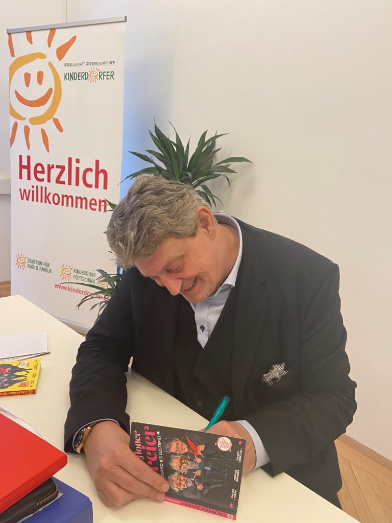 Dieter Chmelar beim Unterschreiben